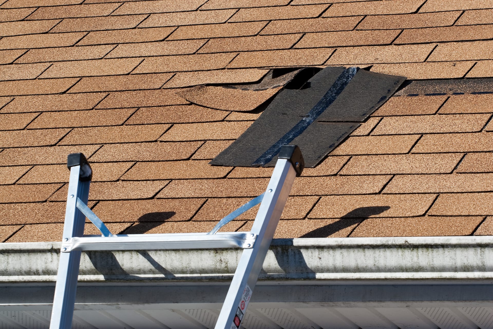 Damaged Roof Shingles Repair Fixing damaged roof shingles.  A section was blown off after a storm with high winds causing a potential leak.