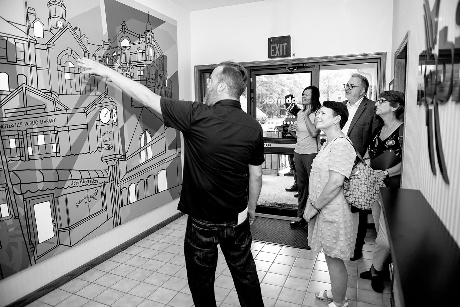 Joe Jorgenson shows the new Adam Hernandez mural to visitors during the Robintek open house