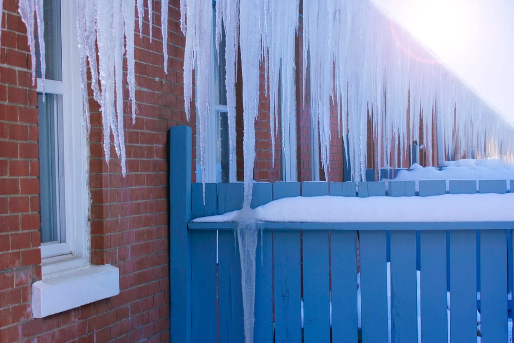 icicles hanging from the gutters on a home showing potential ice dam damage