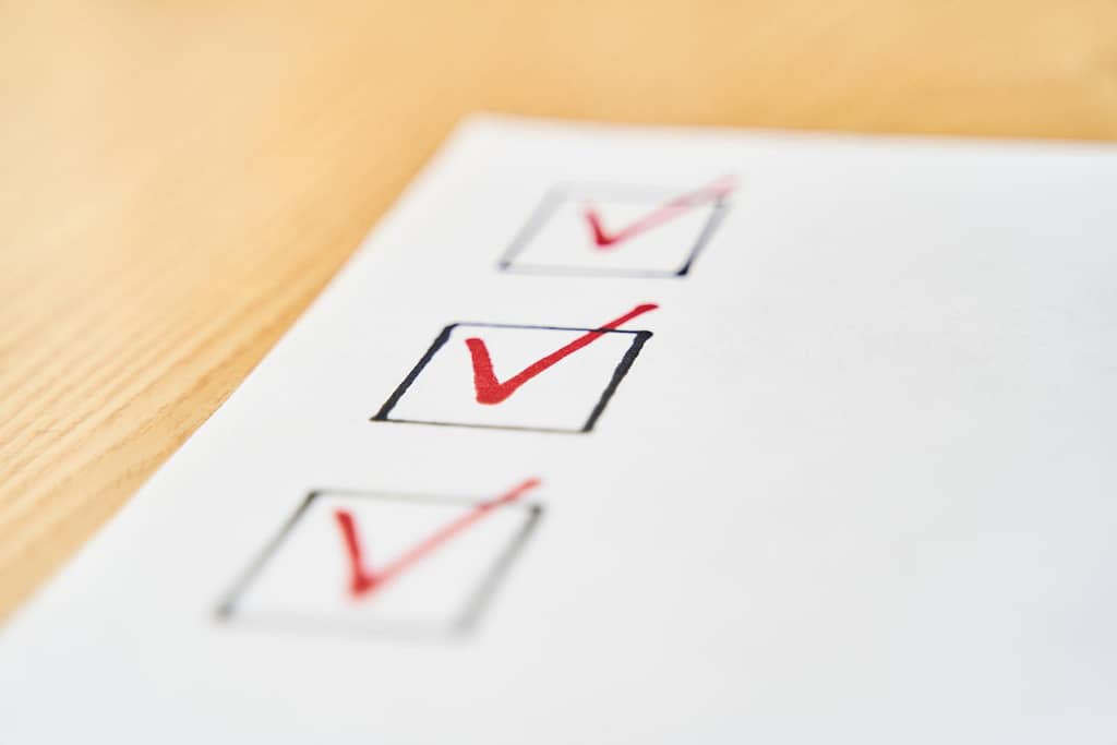 Checklist marked red with a red pen. Close up shot of filled check boxes with red pen. This pre-work checklist is mandatory for every roof repair or replacement at Muth Roofing.