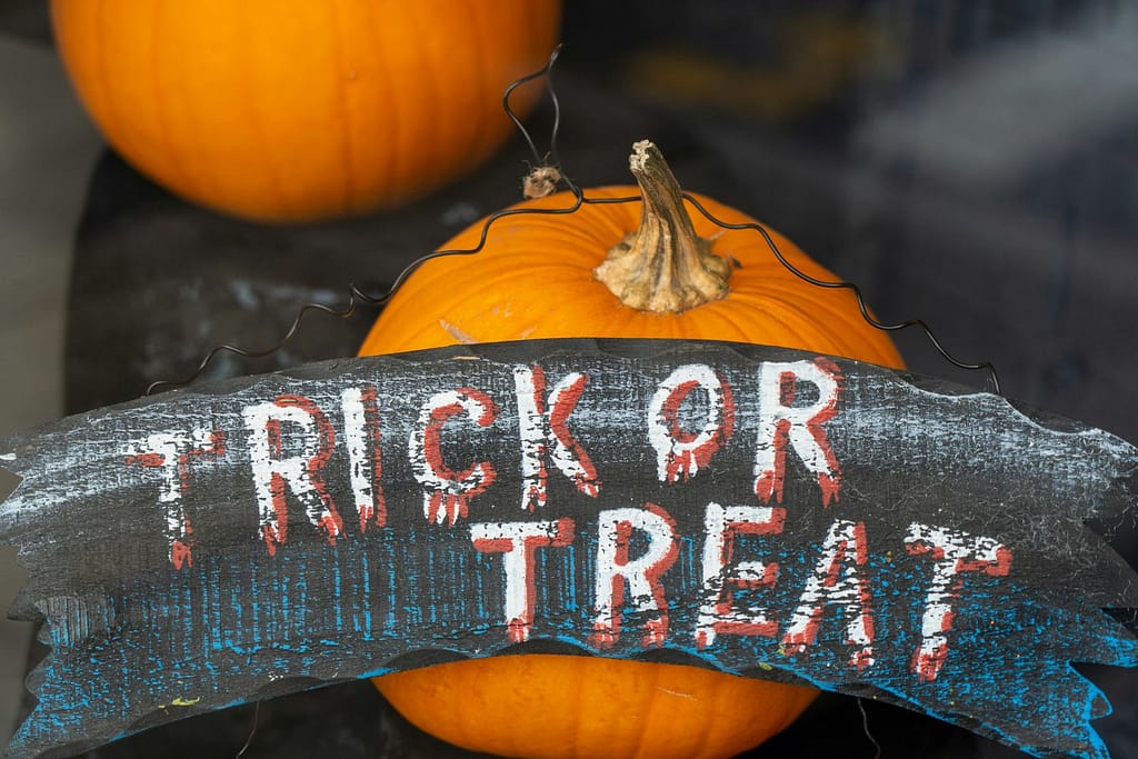A house window celebrating Halloween with a Trick-or-Treat sign