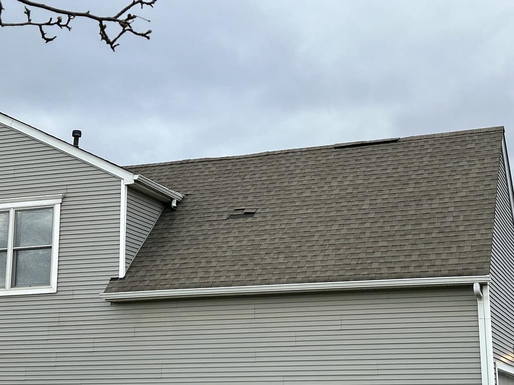 The image displays a residential roof covered with asphalt shingles. The autumn season also comes with several tasks that you should do to prepare your roof for fall.