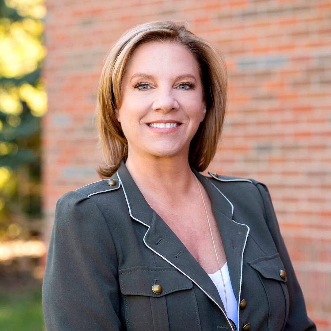 business woman headshot with bick wall background