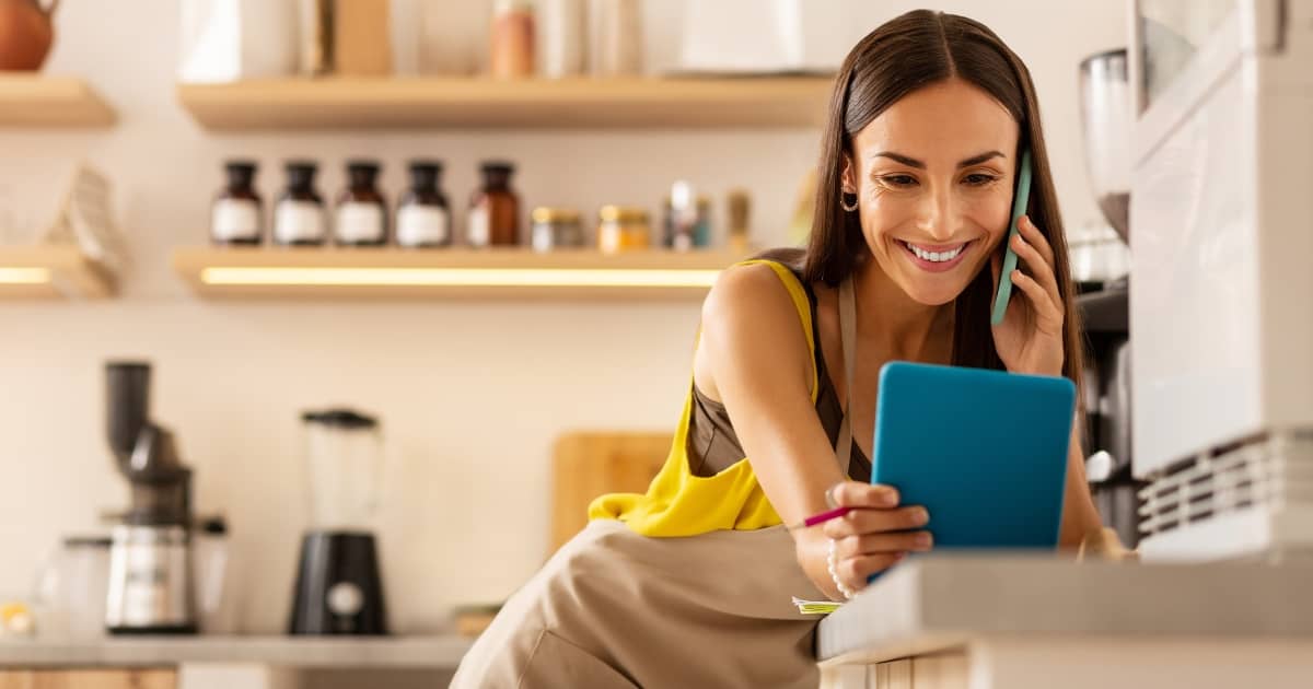 small business owner looking at her tablet while on the phone