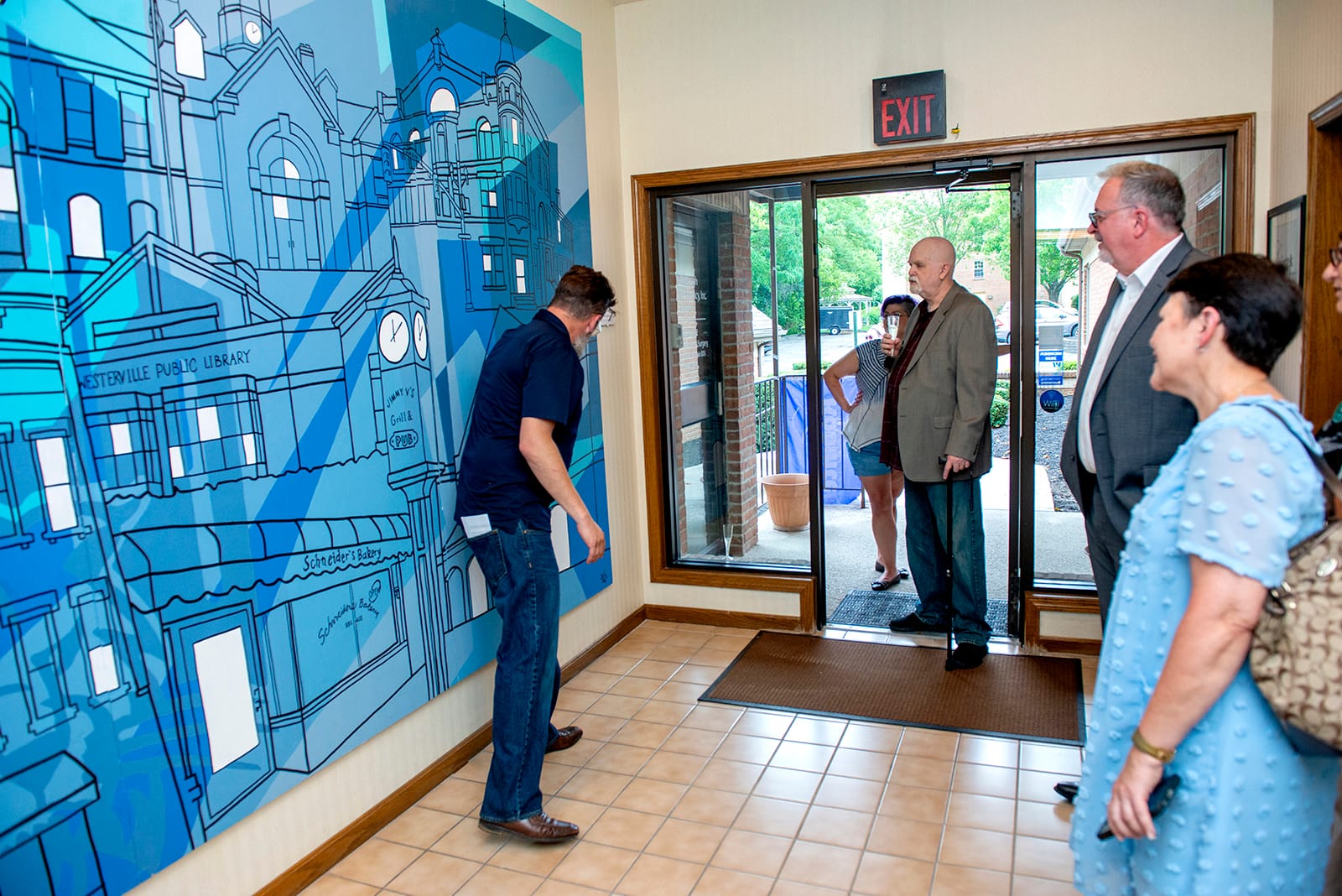 Robintek President Joe Jorgenson explains Robintek's new mural by Adam Hernandez to visitors during Robintek's Open House