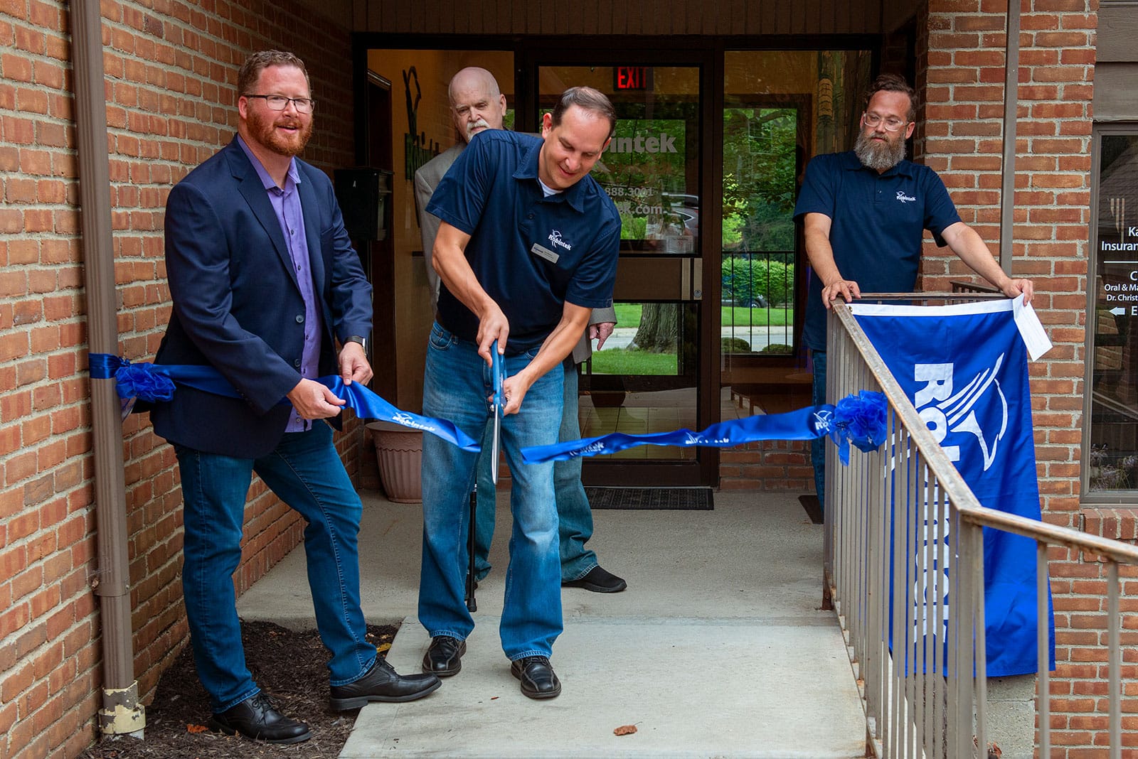 Robintek Leadership stands in front of the new Robintek office in Westerville and cuts the ribbon to formally open their new location