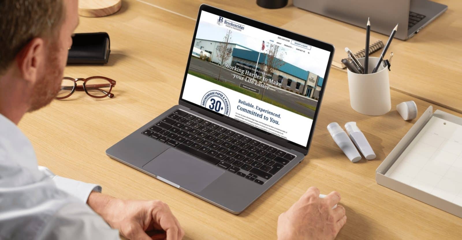 Breckenridge Paper and Packaging homepage pulled up on a laptop while a man looks at it