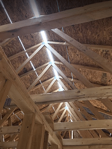 photo of a ridge vent that is new, and letting in light from above as you are looking up into the roof