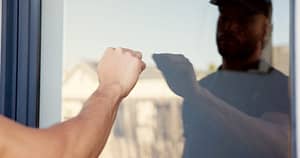 hand-man-and-knocking-on-door-of-house-for-entrance-arrival-alert-and-respect-of-visit-homeowner-guest-glass-and-reflection-with-announcement-show-manners-and-attention-for-welcome-permission-Door-to-Door Roofing Solicitors