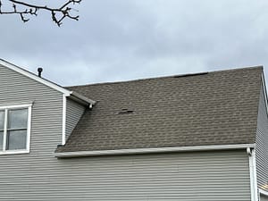 The image displays a residential roof covered with asphalt shingles. The autumn season also comes with several tasks that you should do to prepare your roof for fall.