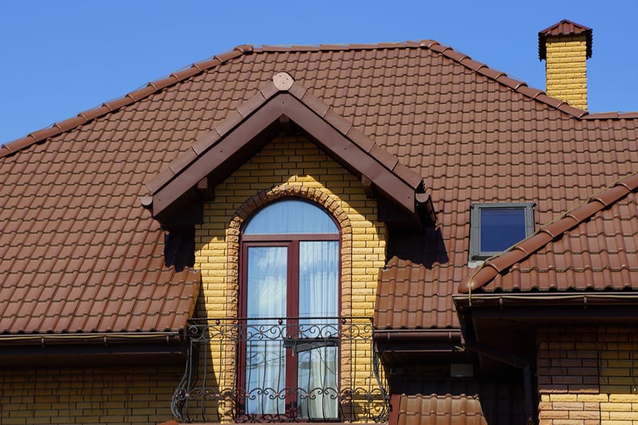 Yellow house with brown metal roofing